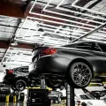 BMW on alignment lift in high-end automotive service shop with modern LED lighting