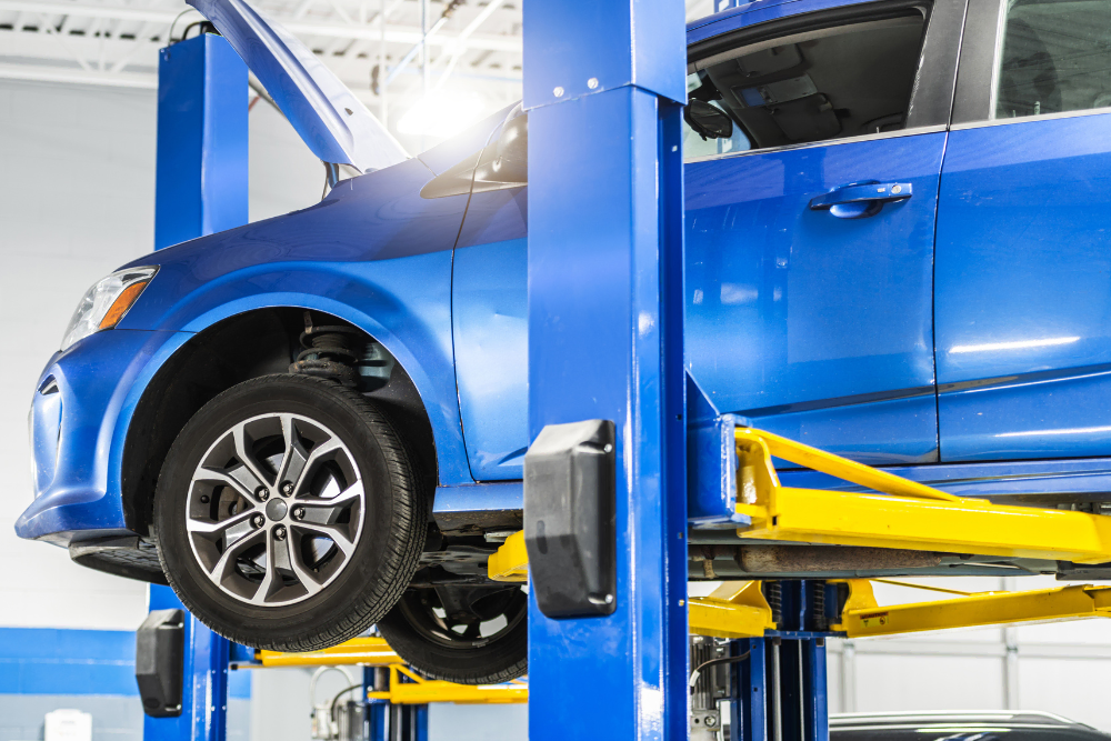 Blue SUV raised on a Forward Lift asymmetrical system, showcasing the best 2-post lift for home garage and shop environments with high-clearance ceilings.