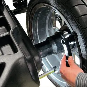 Technician using Rotary R148 Pro Shop 2D Wheel Balancer for precise alignment on wheel