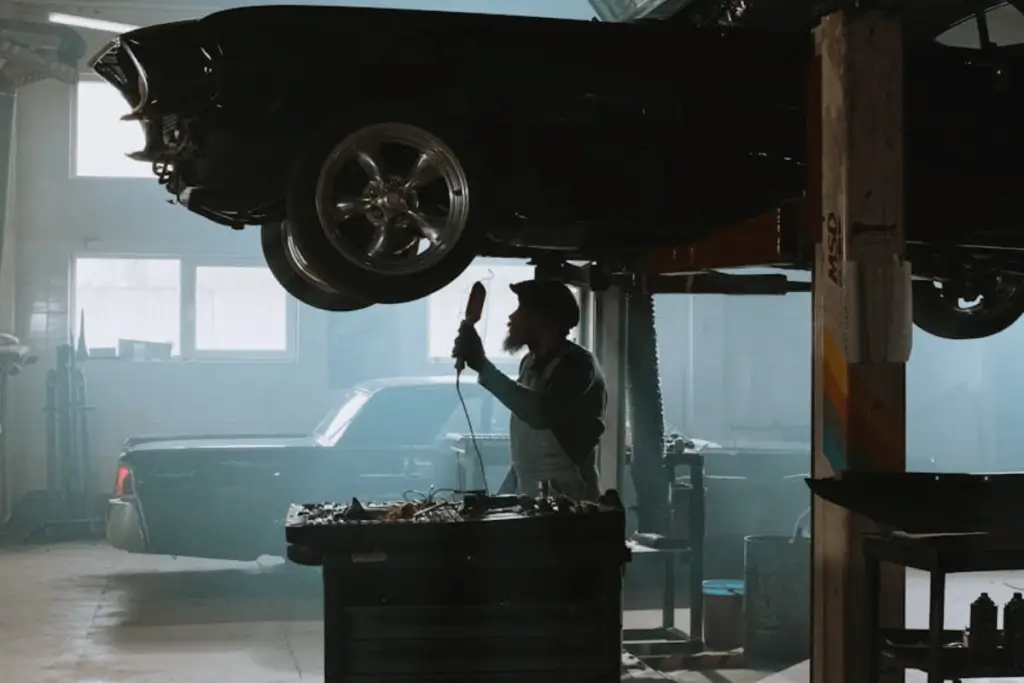Classic car lifted on a four-post garage lift in an automotive enthusiast’s workspace.