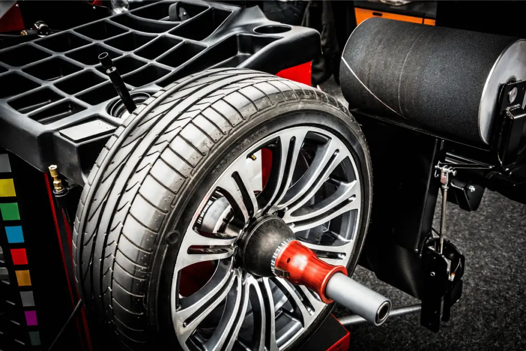 Wheel balancing machine spinning a car tire with precision in an automotive shop.
